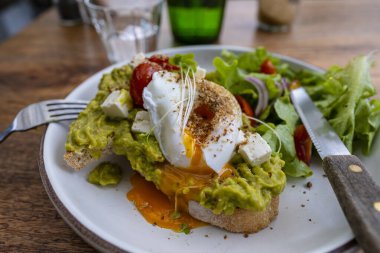Ekşi ekmek, haşlanmış yumurta, avokado hamuru ve kafede taze sebzeler, kapanış, kahvaltı zamanı.
