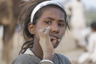 Pushkar, Hindistan - 14 Kasım 2018: Çölde sigara içen Hintli genç kız Thar zamanında Pushkar Camel Mela kutsal şehir Pushkar, Rajasthan, Hindistan, yakın portre