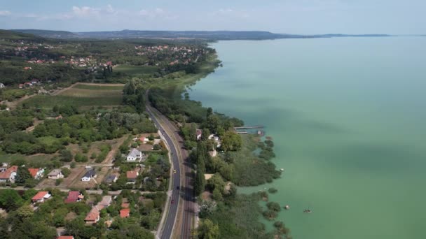 Légi kilátás a Balatonra, autós út a tó mentén, házak, mezők és kertek Magyarországon