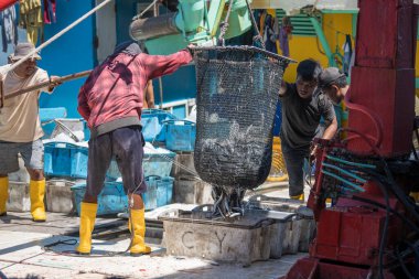 Kota Kinabalu, Malezya - 25 Şubat 2020: Malezyalı balıkçılar taze avlanan balıkları bir gemiden Kota Kinabalu, Sabah, Malezya 'daki sokak filipin pazarındaki plastik konteynırlara yüklüyorlar