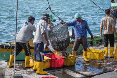 Kota Kinabalu, Malezya - 25 Şubat 2020: Malezyalı balıkçılar taze avlanan balıkları bir gemiden Kota Kinabalu, Sabah, Malezya 'daki sokak filipin pazarındaki plastik konteynırlara yüklüyorlar