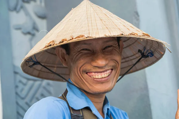 Danang, Vietnam - 10 Temmuz 2020 Danang, Vietnam 'da bir sokak pazarında saman şapkalı mutlu adam