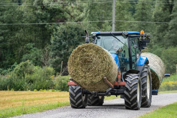 2021年8月28日 オーストリアの田舎道で干し草の俵を担ぐトラクター — ストック写真