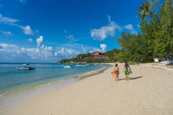 Koh Phangan, Tayland - 13 Şubat 2022: Genç iki kız Tayland 'ın Koh Phangan adasında deniz kenarında yürüyor