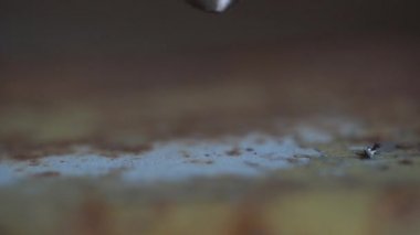 Metal plaka delme. Matkap bir levha metali deliyor, makro. İşçi bir makineye delik açıyor. Yakın plan. Yavaş çekim