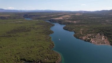 Hırvatistan, Orta Avrupa 'da yaz güneşli bir günde Krka nehri, otostrada ve kemer köprüsünün üzerinde uçmak, seyahat ve doğa kavramı. Güzel manzara ve büyük köprüsü olan mavi deniz. Havadan panorama görünümü