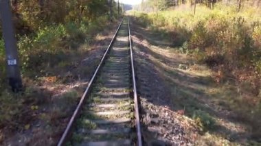 Güneşli bir sonbahar gününde, Ukrayna 'da, ormanın yakınındaki tren rayları üzerinde uçuş. Seyahat ve doğa kavramı
