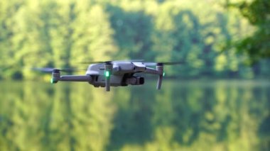 Kiev, Ukrayna - 01 Ekim 2021: DJI Maviç Air 2S İHA 'sı, bir önceki Maviç modeline göre büyük bir güncelleme yaparak, arka planda asılı duruyor. DJI Mavic Air 2S İHA 'sı orman gölünde uçuyor.