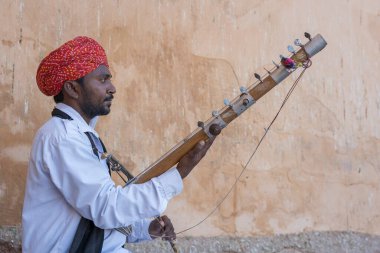 Jaipur, Hindistan - 26 Kasım 2018: Hindistan 'ın eski kenti Jaipur, Rajasthan' daki Amber Kalesi 'nde turistler için Kamaycha adı verilen geleneksel müzik enstrümanında Hint folk müzisyeni
