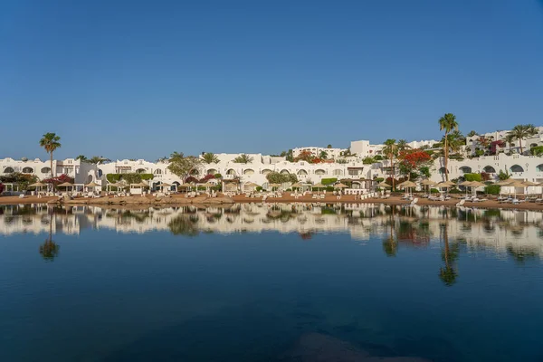 Edificios Tumbonas Sombrillas Reflejan Tranquilo Agua Mar Playa Ciudad Turística —  Fotos de Stock