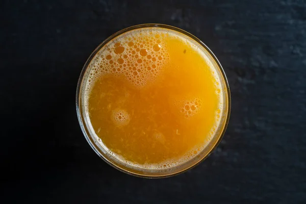 新鮮なオレンジジュースのガラス 閉じます トップビュー マクロ 搾りたての柑橘類ジュース さわやかな朝の飲み物 — ストック写真