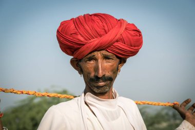 Pushkar, Hindistan - 14 Kasım 2018: Hindistan 'ın kutsal şehri Pushkar, Rajasthan yakınlarındaki Pushkar Camel Mela sırasında çölde yaşayan Hintli adam. Bu fuar dünyanın en büyük deve ticaret fuarı.
