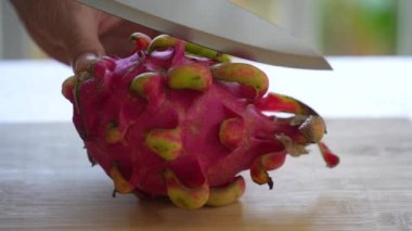 Şef tropikal meyve pitahaya ya da ejderha meyvesini parçalara ayırır. Kesme tahtasında kırmızı pitahaya, yakın çekim, Tayland