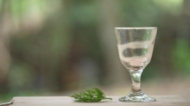 Avokado, muz, dereotu ve baldan taze yeşil meyve suları ahşap masa, Tayland 'da cam bir kadehte, kapat.