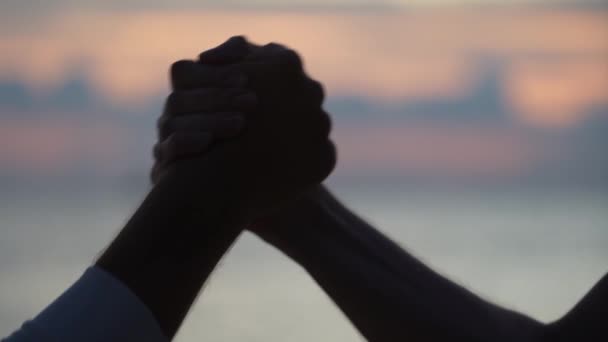 Vriendelijke Handdruk Van Twee Mannen Achtergrond Van Zeewater Tijdens Zonsondergang — Stockvideo