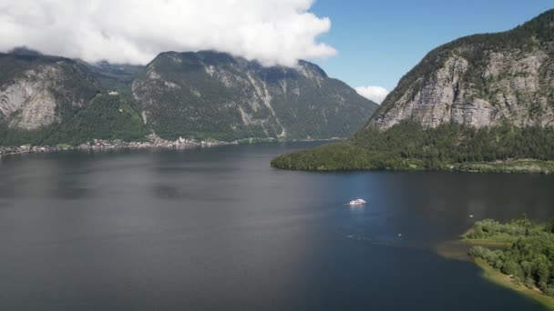 奥地利哈尔斯塔特村旁边的哈尔斯塔特湖 旅游船和高山阿尔卑斯山的空中景观 旅游与自然概念 — 图库视频影像