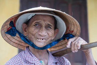 Hoi An, Vietnam - 01 Temmuz 2020: Hoi An, Vietnam 'da bir sokak pazarında saman şapkalı yaşlı kadın