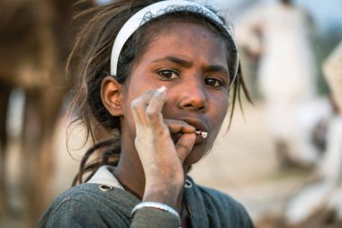 Pushkar, Hindistan - 14 Kasım 2018: Çölde sigara içen Hintli genç kız Thar zamanında Pushkar Camel Mela kutsal şehir Pushkar, Rajasthan, Hindistan, yakın portre