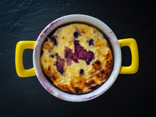 Yabanmersinli süzme peynir güveci, yakın çekim. Siyah arka planda taze böğürtlen güveci. Üst görünüm