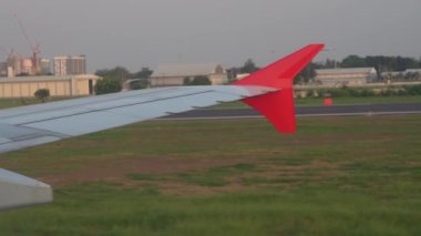 An airplane window view of wing and flaps after landing. Landing aircraft at the airport. View from window. Close up 