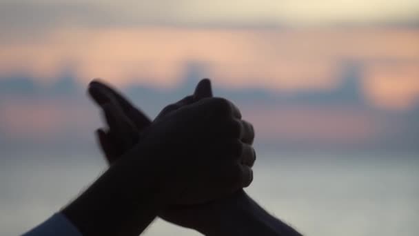 熱帯のビーチで日没の間に海の水の背景に2人の男性の優しい握手 屋外で男性の手を振る 二人の白人男性は外でしっかり握手をしている チームワークと友情を密接に — ストック動画
