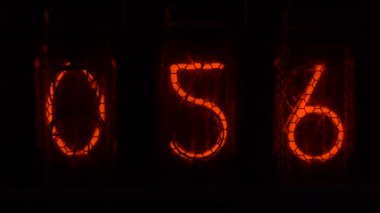 Cihazın üzerindeki vakum tüpü görüntüsü saniyeleri sayıyor. Vintage lamba zamanlayıcısında numaralar gösteriliyor, yakın çekim, nixie tüpü göstergesi. Parlama deşarj göstergesi