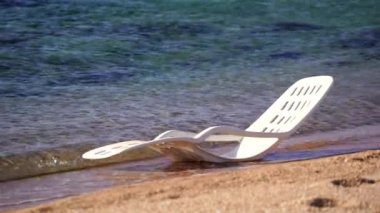 Mısır 'ın Sharm El Sheikh kentindeki tropikal bir plajda deniz suyunda beyaz plastik güneş dinleniyor. Seyahat ve doğa kavramı