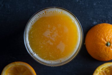 Bir bardak taze portakal suyu, yakın çekim, üst manzara, makro. Taze sıkılmış narenciye suyu. Serinletici sabah içeceği