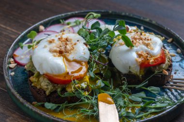 Ekmek tostu, haşlanmış yumurta, avokado hamuru, bezelye mikroçerezi ve kafede taze sebzeler, kapanış, kahvaltı zamanı.