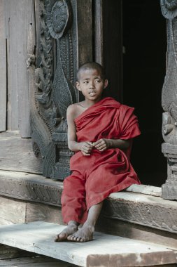 Mandalay, Myanmar, Burma - 17 Ocak 2016: Shwenandaw Manastırı 'na bakan genç keşiş geleneksel Burma mimari tarzında inşa edilmiştir, Mandalay, Myanmar