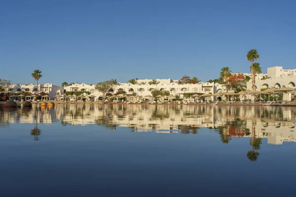 Épületek Napozóágyak Napernyők Tükröződnek Nyugodt Tengervíz Strandon Üdülőhely Város Sharm — Stock Fotó