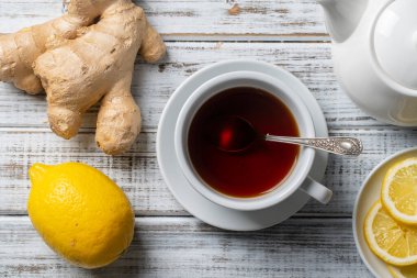 Tahta masada limon ve zencefilli beyaz bir fincan çay. Yaklaş, üst manzara.