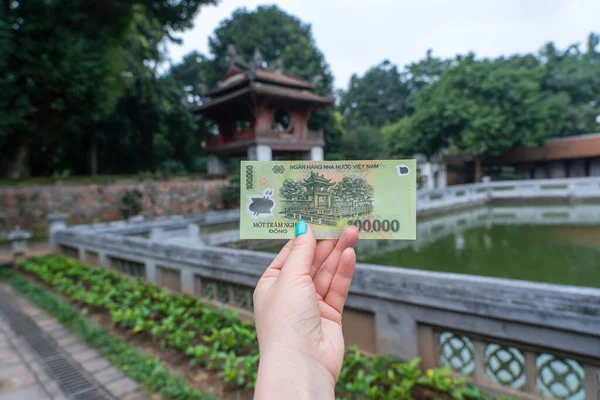 Vietnam 'da Van Mieu Kalesi' nin arka planında 100.000 dong 'luk banknot var. Tasarının tersi, eski Vietnam kalesi Van Mieu veya Edebiyat Tapınağı, Hanoi, Vietnam 'ı betimliyor.