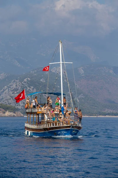 Kemer, Türkiye - 23 Ekim 2017: Turistlerle dolu renkli bir tekne Kemer plajından dönüyor. Kemer turistler arasında çok popülerdir..