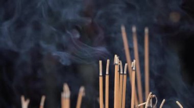 Tütsü dumanla yanıyor ve Budist tapınağı Danang, Vietnam 'da dua eden bir adam var.