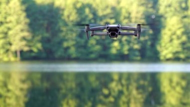 Kiev, Ukrayna - 01 Ekim 2021: DJI Maviç Air 2S İHA 'sı, bir önceki Maviç modeline göre büyük bir güncelleme yaparak, arka planda asılı duruyor. DJI Mavic Air 2S İHA 'sı orman gölünde uçuyor.