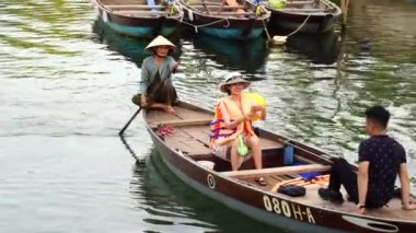 Hoi An, Vietnam - 13 Haziran 2020: Vietnamlılar Hoi Nehri kıyısındaki ahşap bir teknede yüzüyorlar.