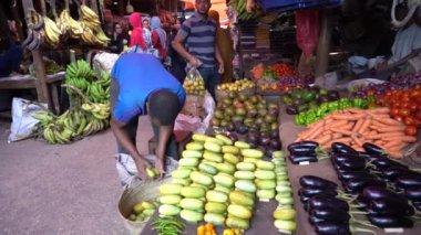 Zanzibar, Tanzania - november 03, 2019 : african man sells raw vegetables at the local street market of Zanzibar island, Tanzania, East Africa