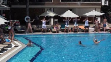 Bodrum, Türkiye - Eylül 08, 2019: Animatörler turistleri oteldeki yüzme havuzu yakınlarında ağırlıyor. Tatillerde dinlenme kavramı