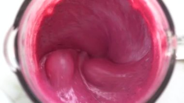 Tropik kırmızı ejderha meyvesi ve beyaz hindistan cevizi sütüyle karıştırılmış tatlı muz. Pembe meyve kokteyli. Sağlıklı yaşam tarzı kavramı. Yakın çekim, yavaş çekim, üst görünüm