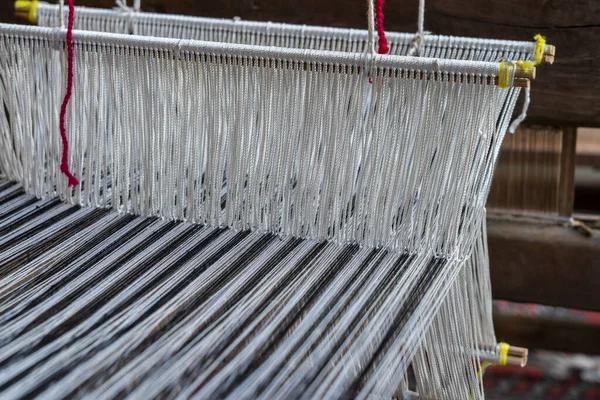 Old hand-weaving vintage wooden loom being used to make fabric, close up, Vietnam