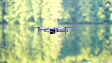 Kiev, Ukrayna - 01 Ekim 2021: DJI Maviç Air 2S İHA 'sı, bir önceki Maviç modeline göre büyük bir güncelleme yaparak, arka planda asılı duruyor. DJI Mavic Air 2S İHA 'sı orman gölünde uçuyor.