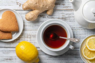 Tahta masada limon ve zencefilli beyaz bir fincan çay. Yaklaş, üst manzara.