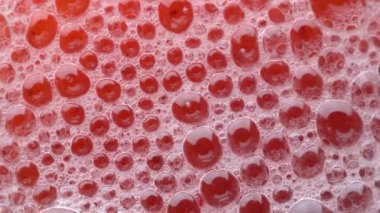 Bubbles on the surface of the drink of red viburnum soda drink on background. Fresh drink of scarlet cranberry or cherry or red currant or viburnum