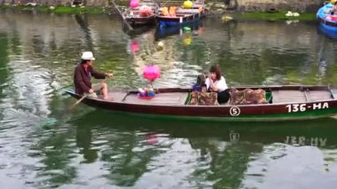 Hoi An, Vietnam - 5 Haziran 2020: Vietnamlı turistler Hoi Nehri kıyısındaki ahşap bir teknede yüzüyorlar.