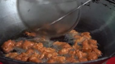 Metal tavada kızartılmış hamur ve sıcak yağda yakın çekim yapıyoruz. Taylandlıların kahve ya da sütle yemesi için sabah atıştırması. Bangkok, Tayland