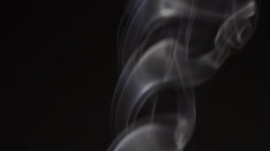 Siyah arka planda beyaz duman yavaş çekimde. Beyaz buhar döner ve yükselir.