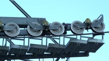 Teleferik toplu taşıma aracının görüntüsü. Mavi gökyüzü arka planında teleferikler. Kablo araba kulesi yuvarlanan tekerlekleri kapatır