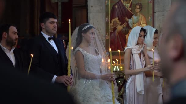 2018年10月27日 佐治亚州佐治亚州第比利斯附近历史名城Mtskheta的基督教东正教教堂 新娘和新郎拿着点燃的蜡烛举行婚礼 — 图库视频影像