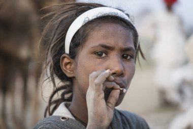 Pushkar, Hindistan - 14 Kasım 2018: Çölde sigara içen Hintli genç kız Thar zamanında Pushkar Camel Mela kutsal şehir Pushkar, Rajasthan, Hindistan, yakın portre